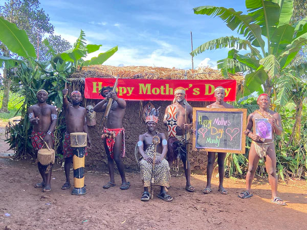 The Hunter Team holding a personalized Mother’s Day message board in an authentic African village setting