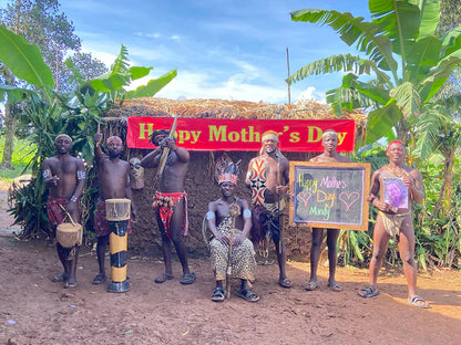 The Hunter Team holding a personalized Mother’s Day message board in an authentic African village setting