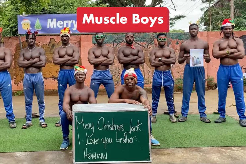 The Muscle Team flexing and celebrating with a custom 'Merry Christmas' sign.