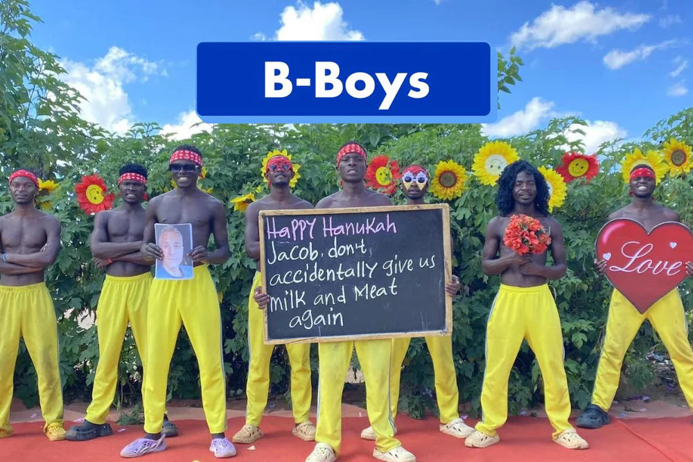 The African B-Boys team holding a 'Happy Hanukkah' message board during a vibrant holiday celebration